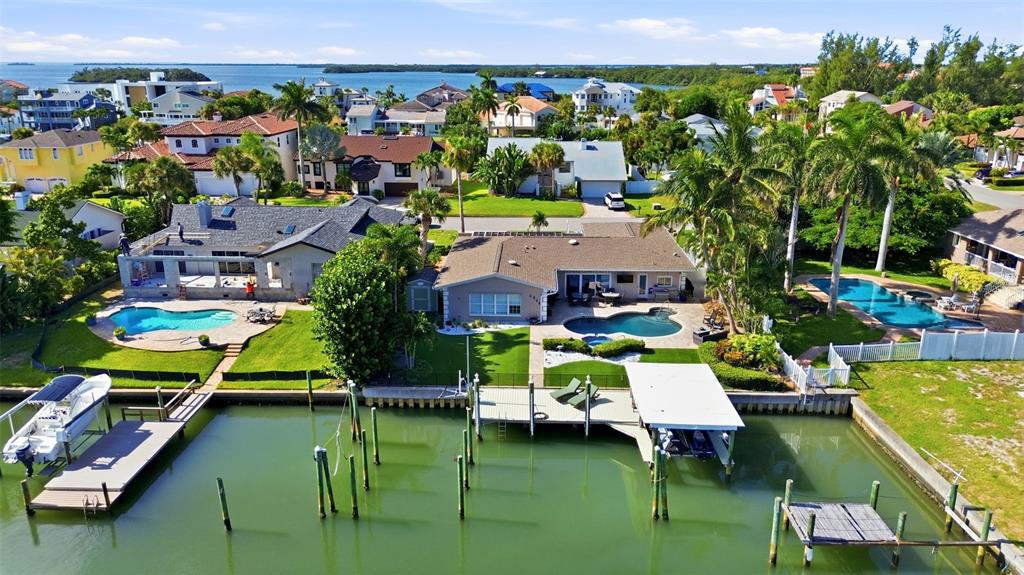 An aerial view of waterfront houses with swimming pools, private docks, and boat lifts — 137 12TH STREET E, TIERRA VERDE, FL