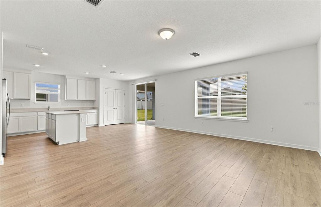 A living room features a gray accent wall, a television, and a view of water — 1543 HARTRIDGE COURT, LAKE ALFRED, FL