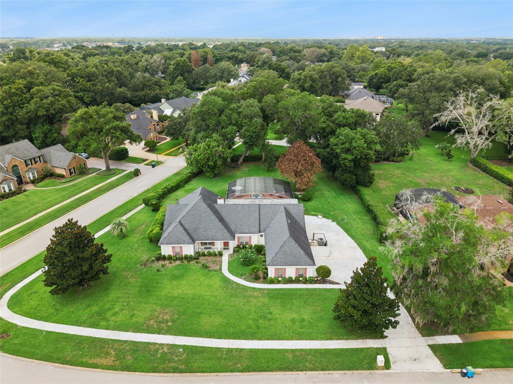 An aerial view shows a single-story house with a pool enclosure and a large lawn — 2512 TRYON PLACE, WINDERMERE, FL