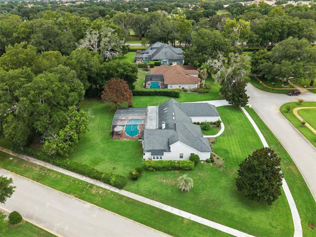A single-story house with a red front door, dark shutters, and a large front lawn — 2512 TRYON PLACE, WINDERMERE, FL