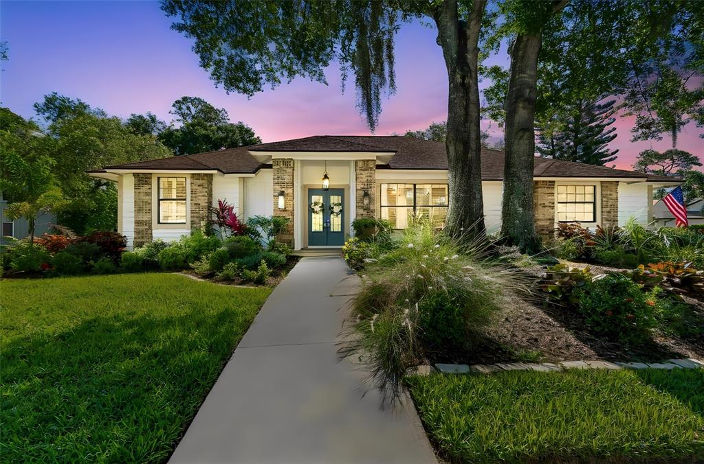 A single-story house with a brick facade, a blue front door, and a concrete walkway — 4627 TRAILS DRIVE, SARASOTA, FL