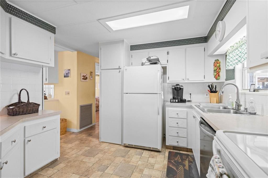 A kitchen with white cabinets, a white refrigerator, and light-colored tile flooring — 2100 KINGS HIGHWAY UNIT 27, PORT CHARLOTTE, FL