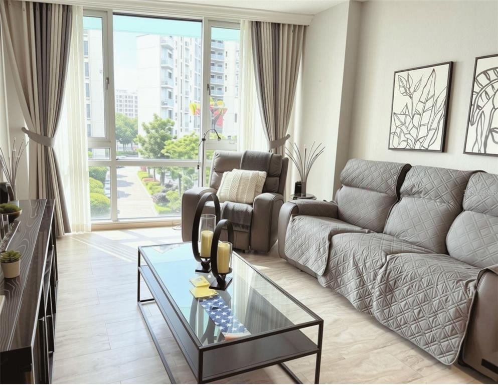 A bedroom features a bed, a black dresser with a television, and a window — 322 E CENTRAL BOULEVARD UNIT 714, ORLANDO, FL