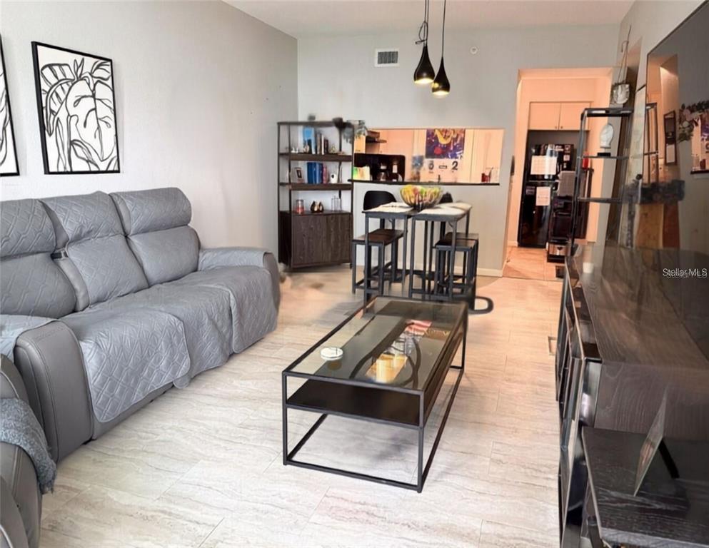 A kitchen features light wood cabinets, black appliances, and dark granite countertops — 322 E CENTRAL BOULEVARD UNIT 714, ORLANDO, FL