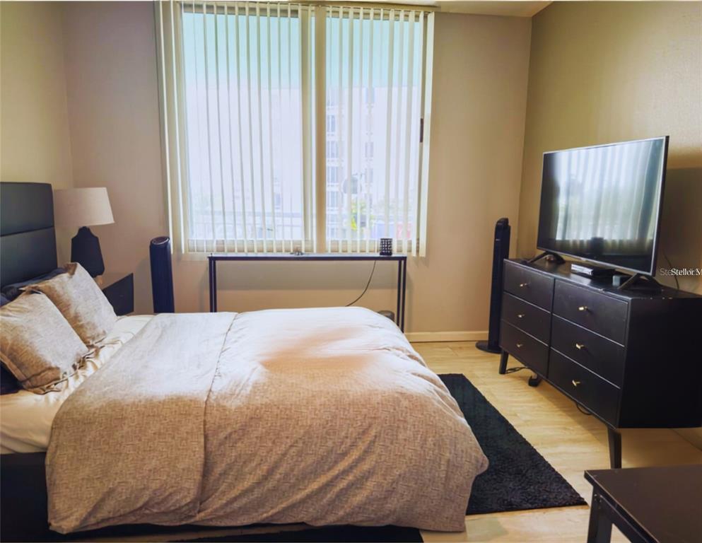 A bathroom features a dark granite vanity, a white cabinet, and a shower-tub combination — 322 E CENTRAL BOULEVARD UNIT 714, ORLANDO, FL