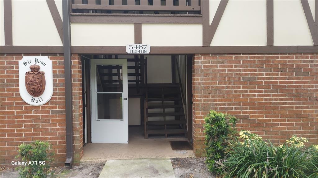 A kitchen features white cabinets, a double-basin sink, subway tile backsplash, and a glass-paneled door — 5467 HANSEL AVENUE UNIT H15, ORLANDO, FL