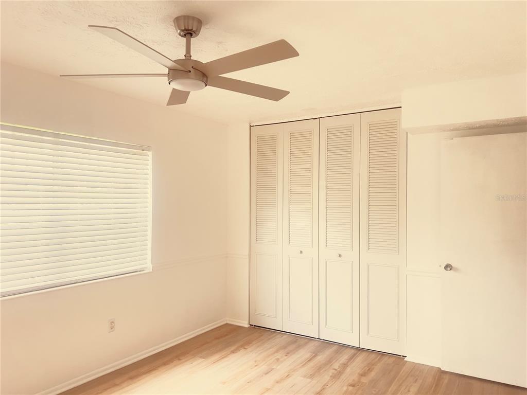 A white kitchen features a Frigidaire refrigerator, a microwave, and marble-patterned backsplash tiles — 5467 HANSEL AVENUE UNIT H15, ORLANDO, FL