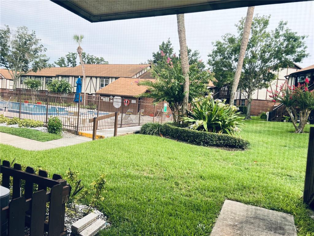 A bright kitchen features white cabinets, white appliances, and a door with a window — 5467 HANSEL AVENUE UNIT H15, ORLANDO, FL