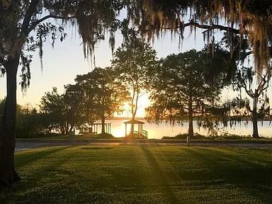 A gazebo stands near a lake at sunset, framed by trees with hanging Spanish moss — 250 KILLARNEY, WINTER PARK, FL