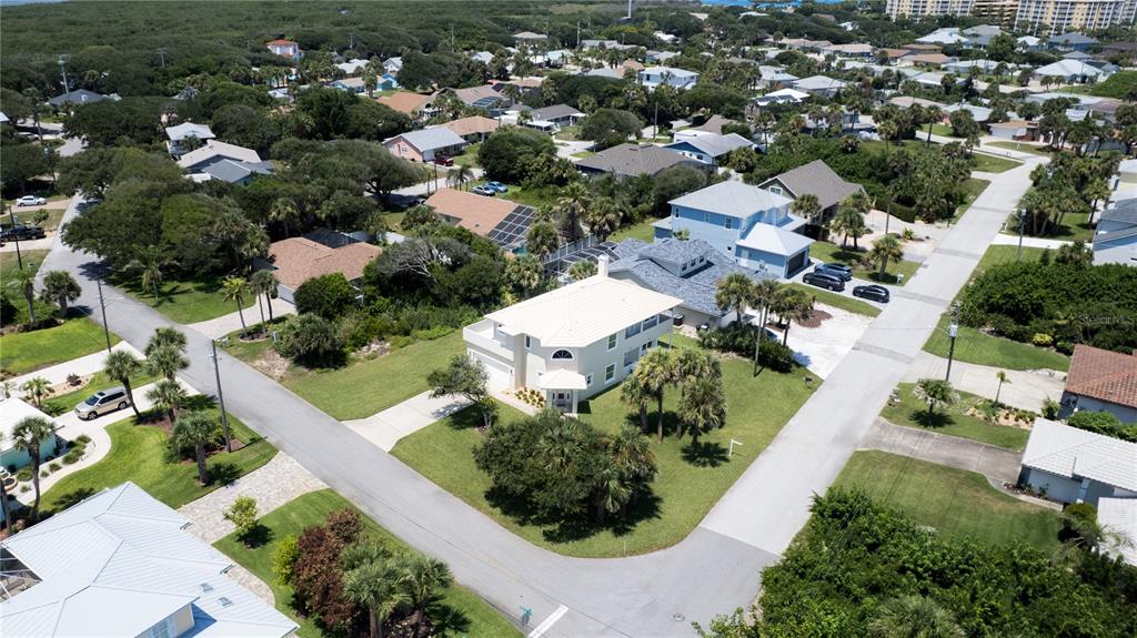 An aerial view shows a two-story house with a light-colored roof in a residential neighborhood — 50 ALBERTA AVENUE, PONCE INLET, FL