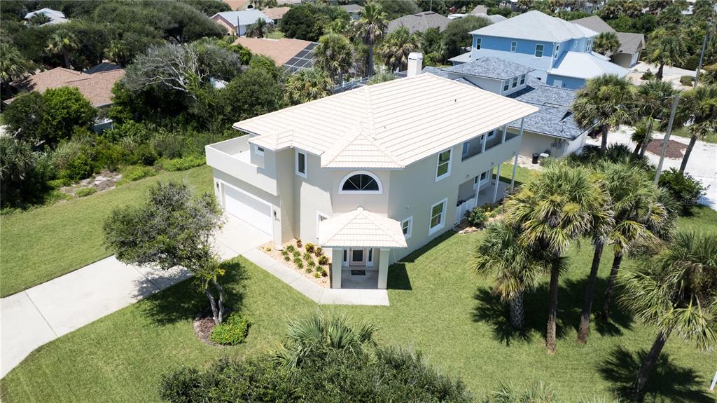 An aerial view shows a two-story beige house with a light-colored roof and palm trees — 50 ALBERTA AVENUE, PONCE INLET, FL