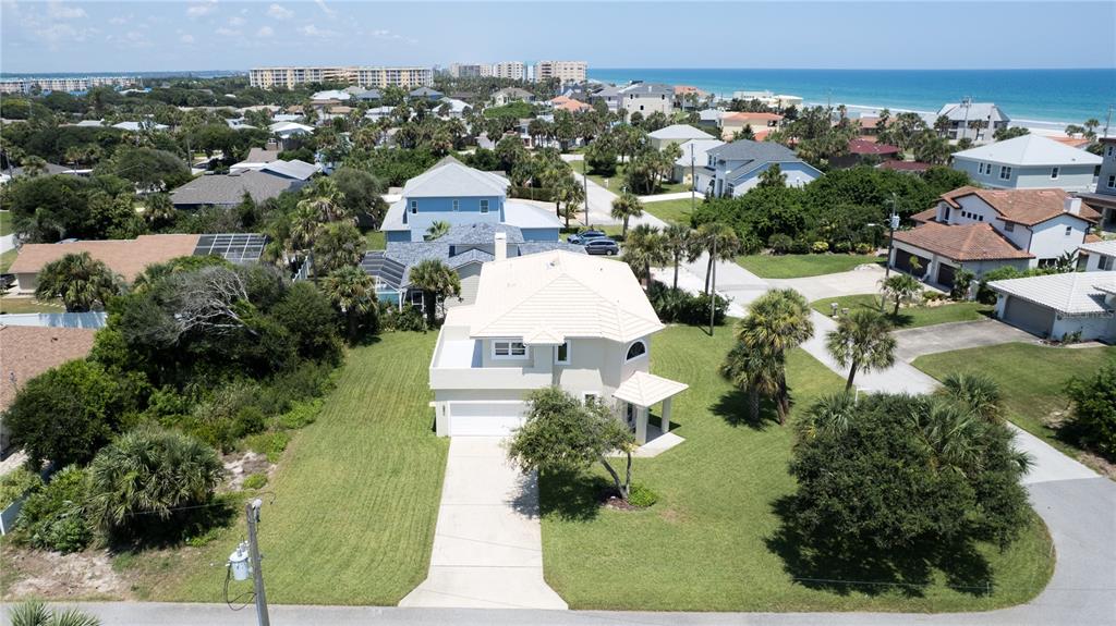 An aerial view shows a two-story house with a light-colored exterior and a large lawn — 50 ALBERTA AVENUE, PONCE INLET, FL