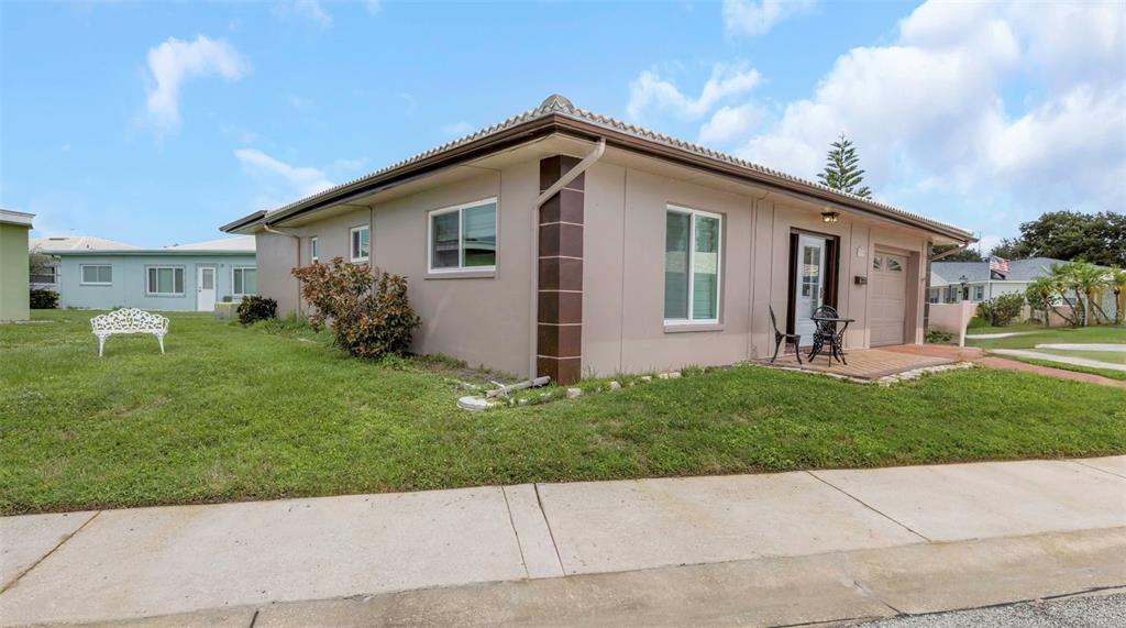 A single-story house with a tan exterior, a small front porch, and a grassy yard — 5355 FERNDALE PLACE N, PINELLAS PARK, FL