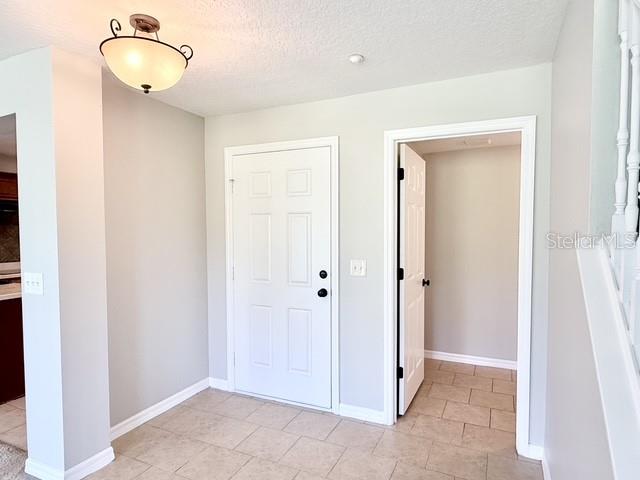 A tiled entryway features a white door, an open doorway, and a ceiling light fixture — 218 WINTER NELLIS CIRCLE, WINTER GARDEN, FL