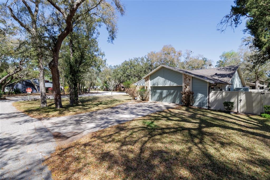 A single-story house with a concrete driveway, stone accents, and a light-colored vinyl fence — 317 OAK FERN CIRCLE, ORMOND BEACH, FL