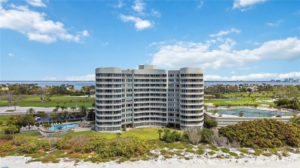 An exterior view of a multi-story apartment building with a swimming pool and oceanfront beach — 775 LONGBOAT CLUB ROAD UNIT 401, LONGBOAT KEY, FL