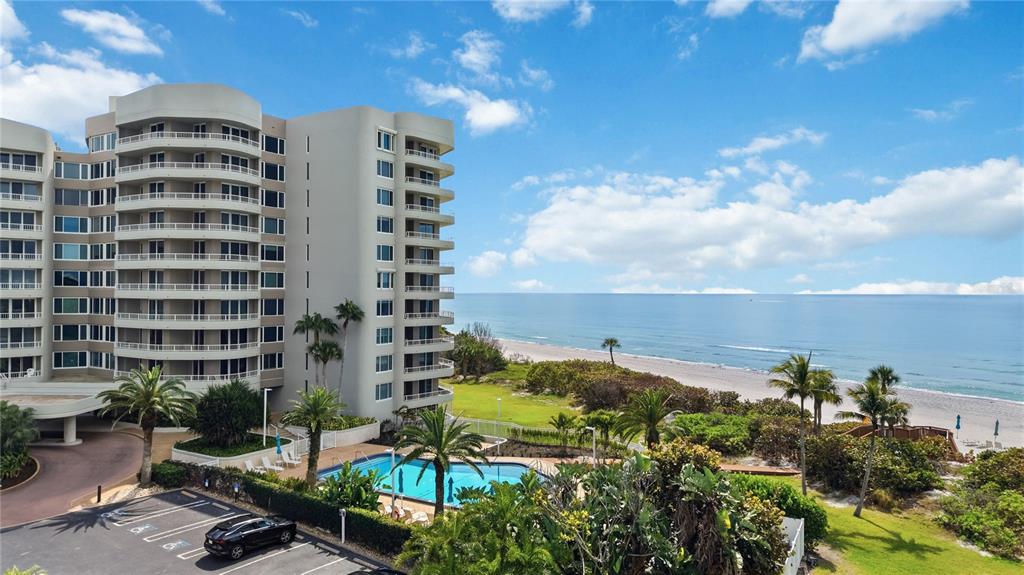 An aerial view shows a multi-story residential building with a pool, tennis courts, and golf course — 775 LONGBOAT CLUB ROAD UNIT 401, LONGBOAT KEY, FL