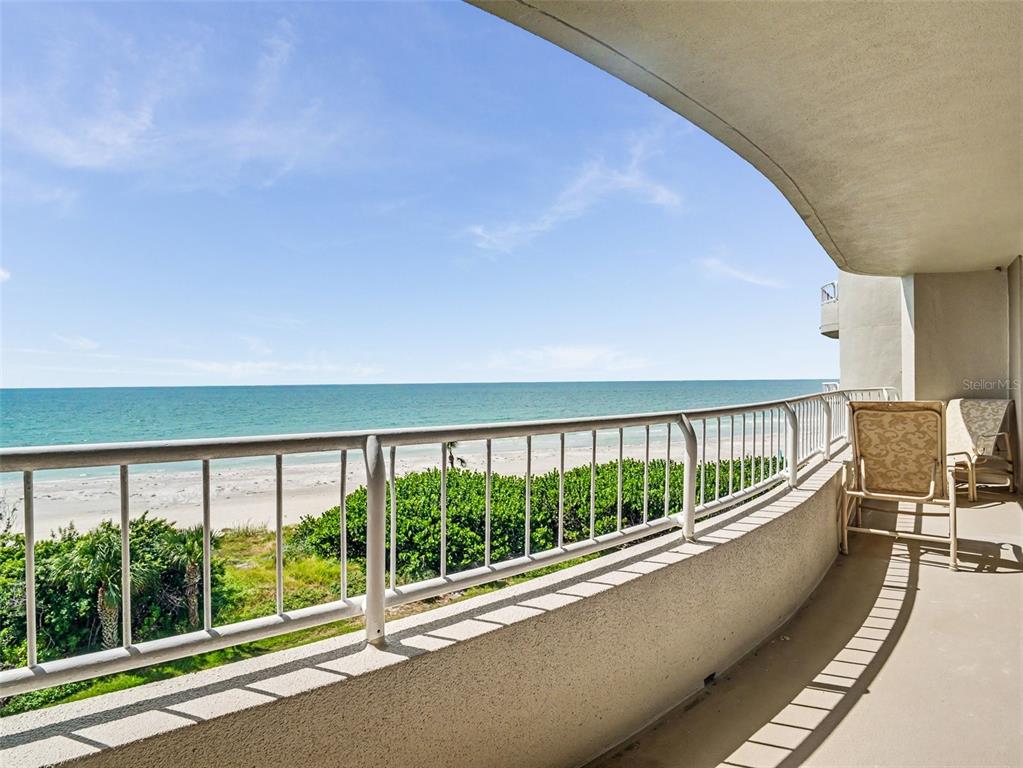 A high-angle view of a sandy beach and ocean at sunset under a cloudy sky — 775 LONGBOAT CLUB ROAD UNIT 401, LONGBOAT KEY, FL