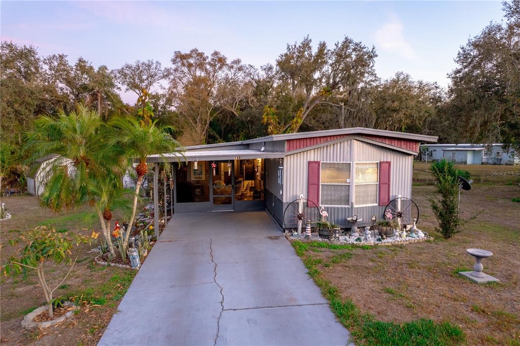 A single-story mobile home with a concrete driveway, a screened porch, and a metal roof — 1381 SE LAKE RD, ARCADIA, FL
