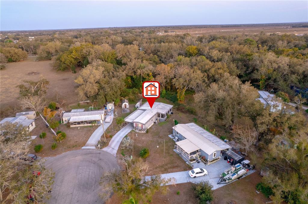 An aerial view shows several mobile homes situated on a wooded lot with driveways — 1381 SE LAKE RD, ARCADIA, FL
