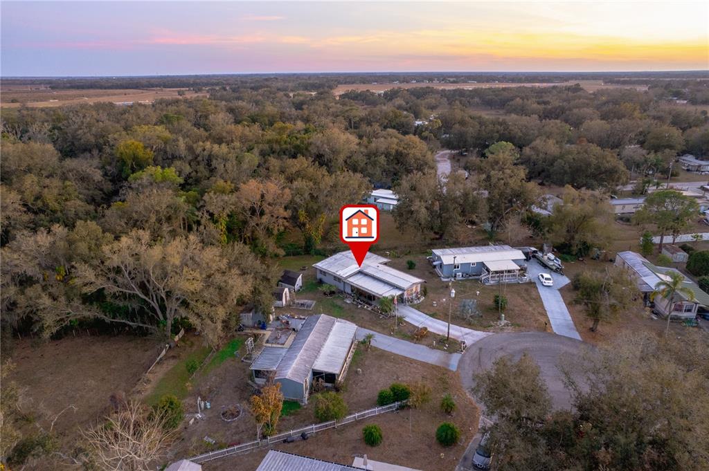 An aerial view shows a residential property with multiple buildings, a driveway, and surrounding trees — 1381 SE LAKE RD, ARCADIA, FL