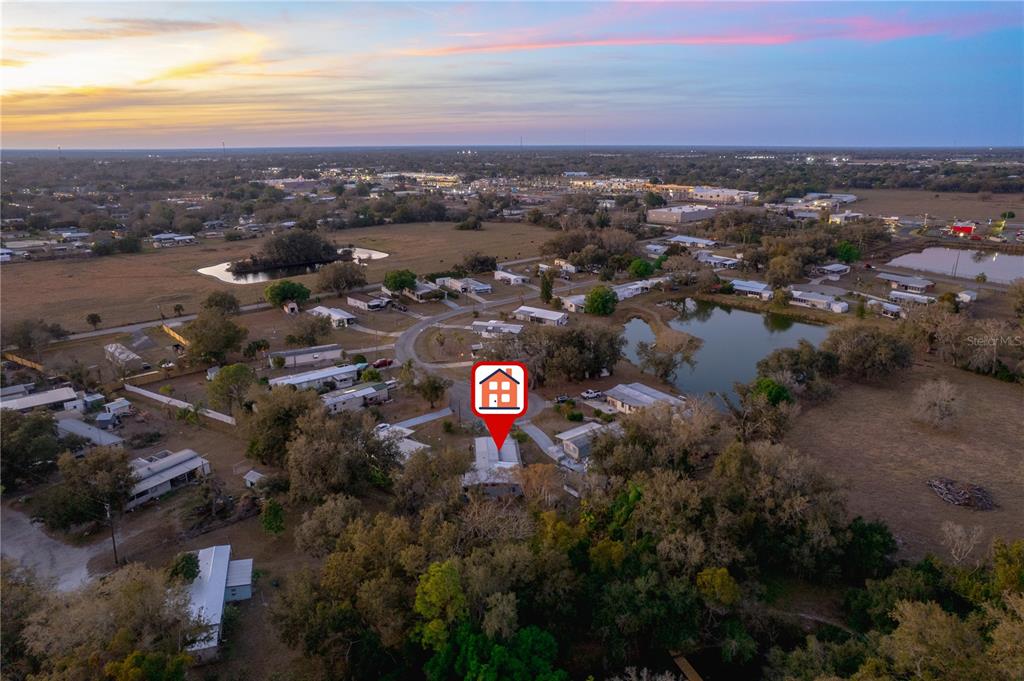 An aerial view shows a house marked with a pin in a rural residential area — 1381 SE LAKE RD, ARCADIA, FL