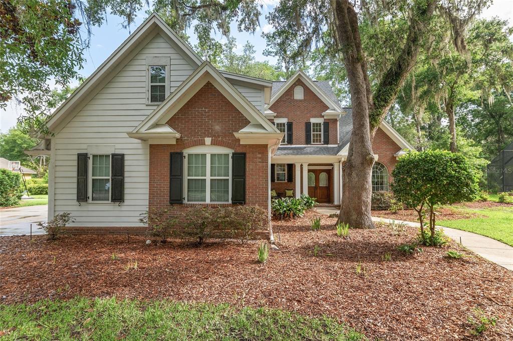 A two-story house with a brick and siding exterior, black shutters, and a front porch — 5512 NW 51ST AVENUE, GAINESVILLE, FL