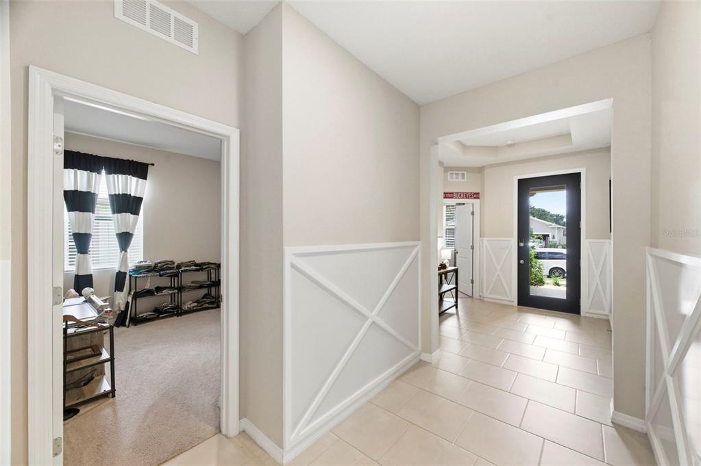 A tiled entryway leads to a front door and an adjacent room with carpeted flooring — 10403 LAXER CAY LOOP, SAN ANTONIO, FL