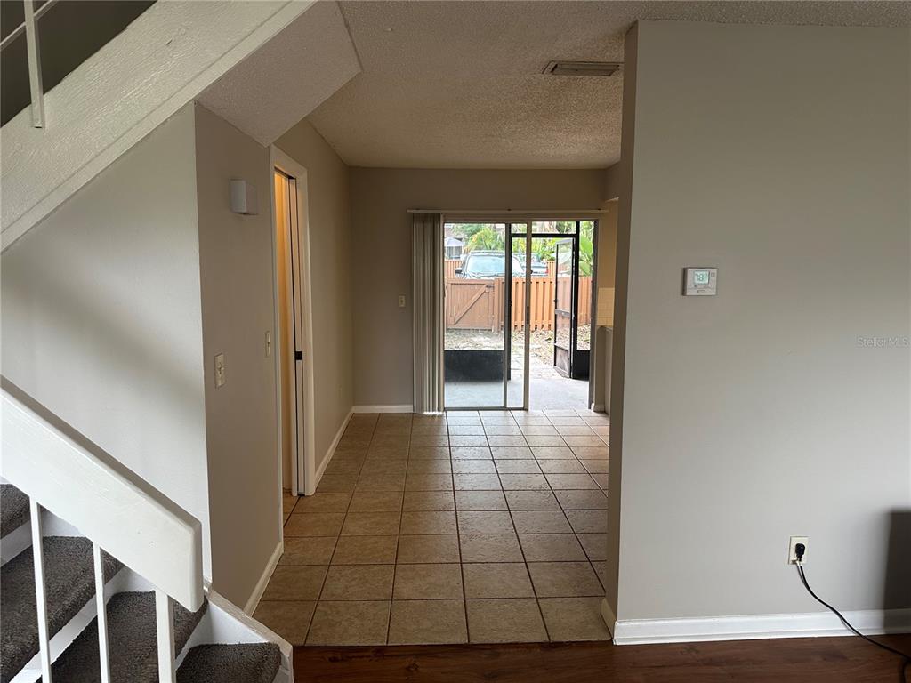 A view from a living area toward a tiled dining space with sliding glass doors — 14752 MORNING DRIVE, LUTZ, FL