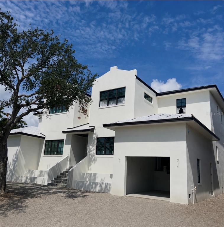 A two-story white stucco house with a flat roof, dark window frames, and a garage — 2051 ILLINOIS AVENUE NE, ST PETERSBURG, FL