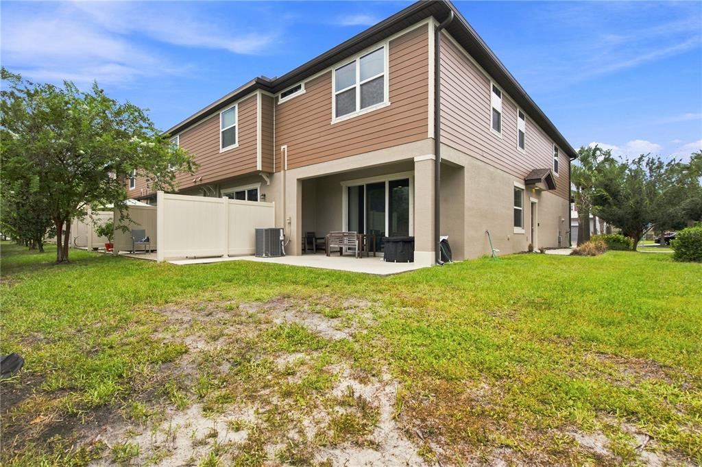 The exterior of a two-story townhouse features a concrete patio and a fenced backyard — 9237 HILLCROFT DRIVE, RIVERVIEW, FL