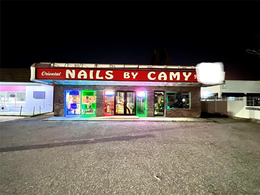 A commercial building with a red sign reading Nails by Camy at night — 3080 BEE RIDGE ROAD, SARASOTA, FL