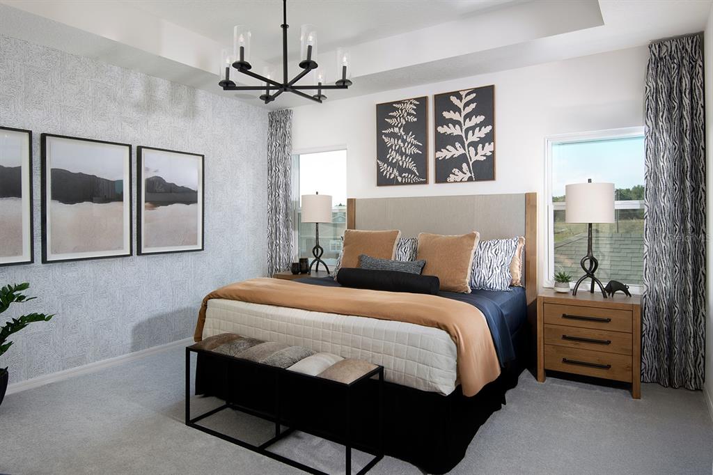 A modern bedroom features a king bed, patterned wallpaper, a chandelier, and two bedside lamps — 1532 SILVER LINING WAY, APOPKA, FL