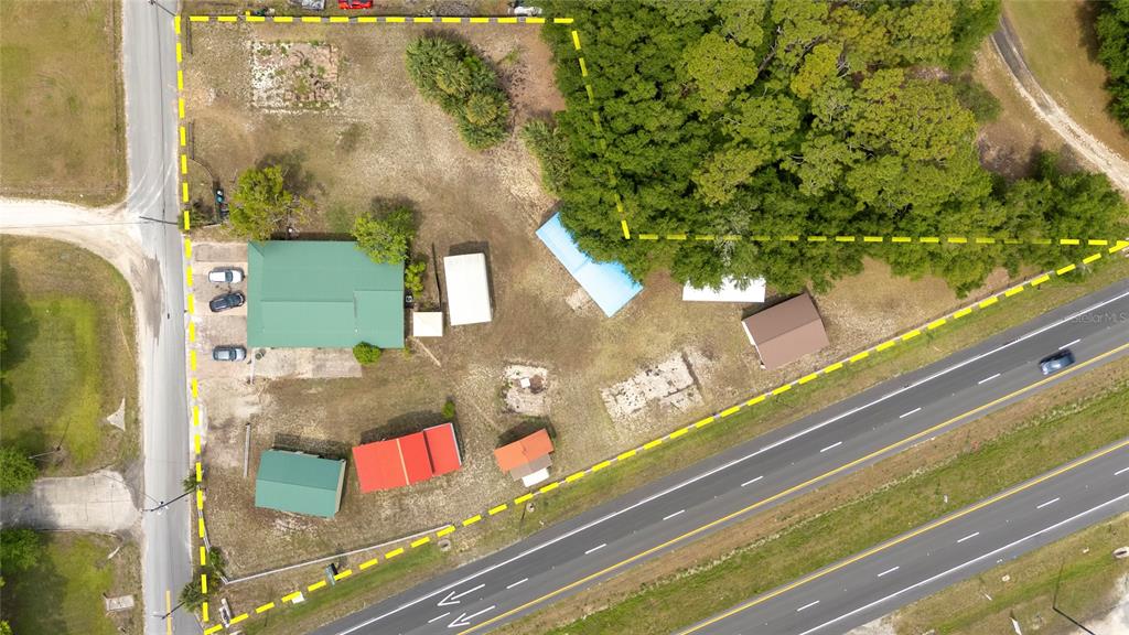 An aerial view shows a property with multiple buildings, trees, and a road — 3526 ELLIS LANE, MIMS, FL