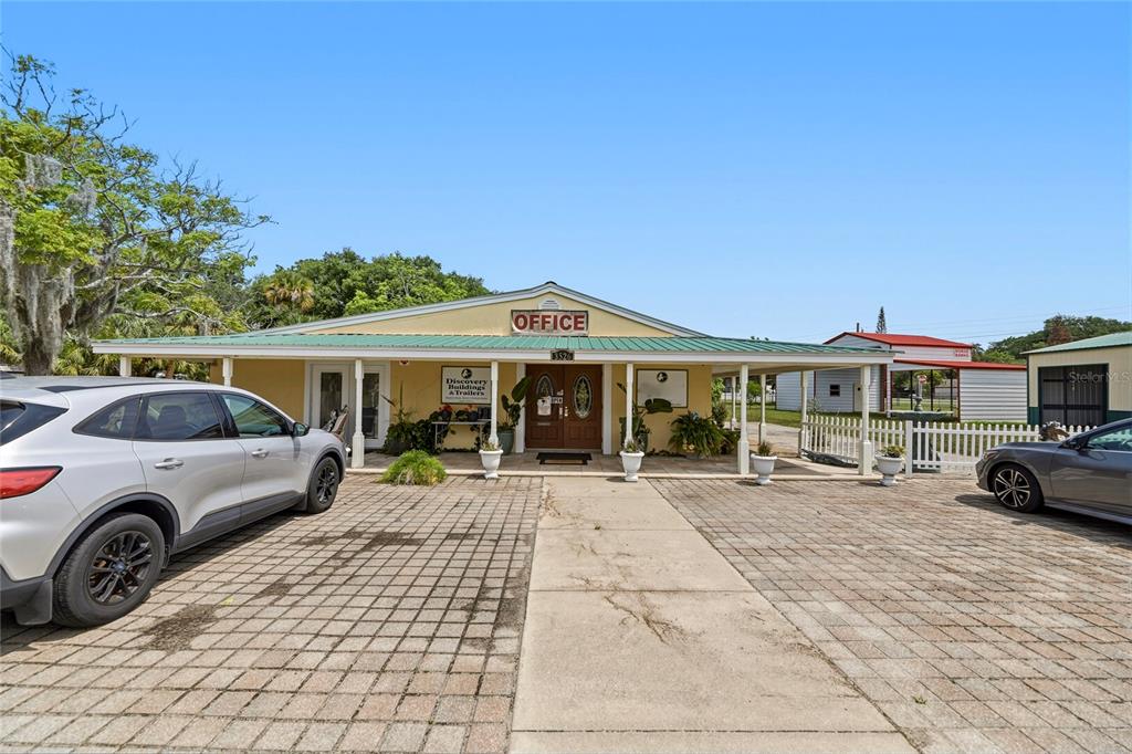 A single-story office building with a covered porch and a paved parking lot — 3526 ELLIS LANE, MIMS, FL