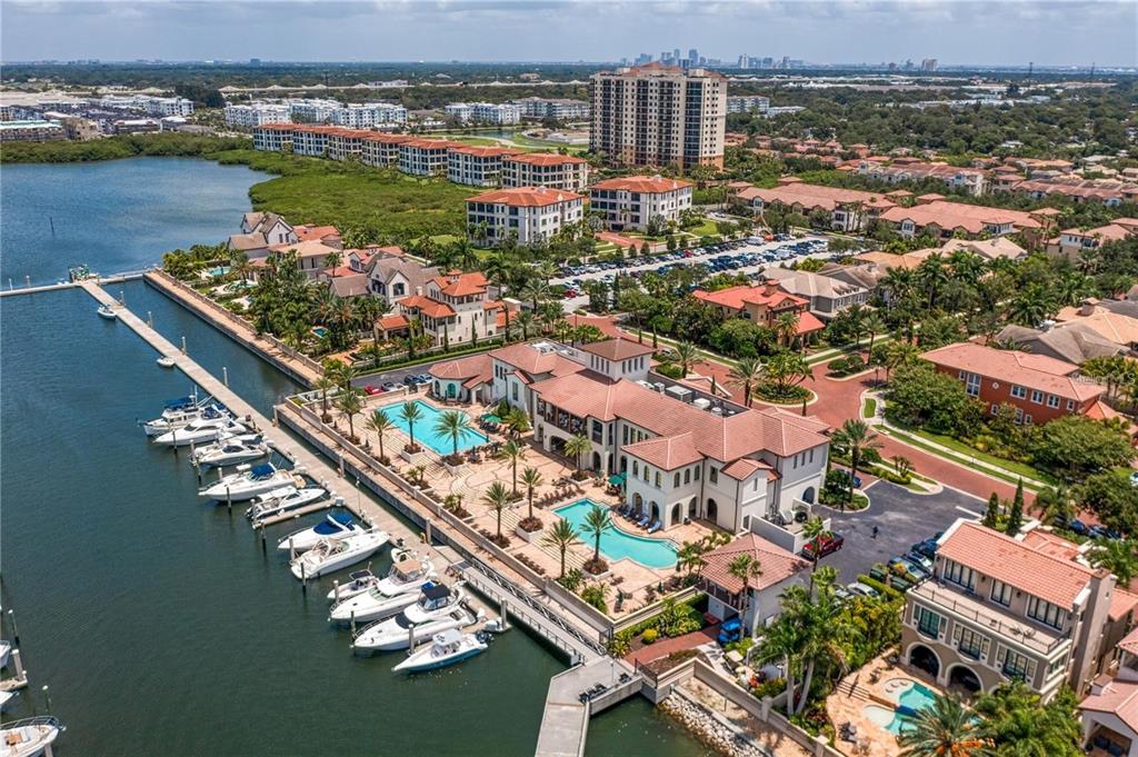 An aerial view shows a large waterfront estate with two pools and several docked boats — 6002 YEATS MANOR DRIVE UNIT 101, TAMPA, FL