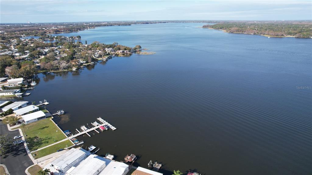 An aerial view shows a large lake with residential docks and waterfront homes — 55 LEXINGTON COURT UNIT 12, PALM HARBOR, FL