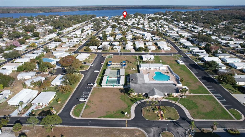 Aerial view of a residential community featuring a clubhouse, swimming pool, and tennis courts — 55 LEXINGTON COURT UNIT 12, PALM HARBOR, FL