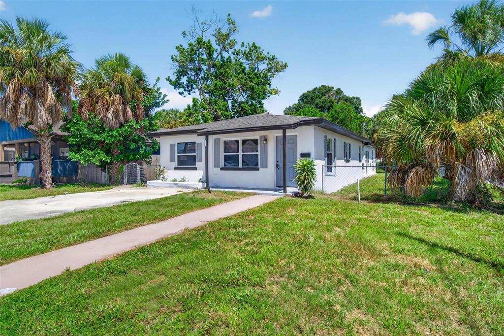 A single-story white house with a gray roof sits on a grassy lot with palms — 1901 MELROSE AVENUE S, ST PETERSBURG, FL