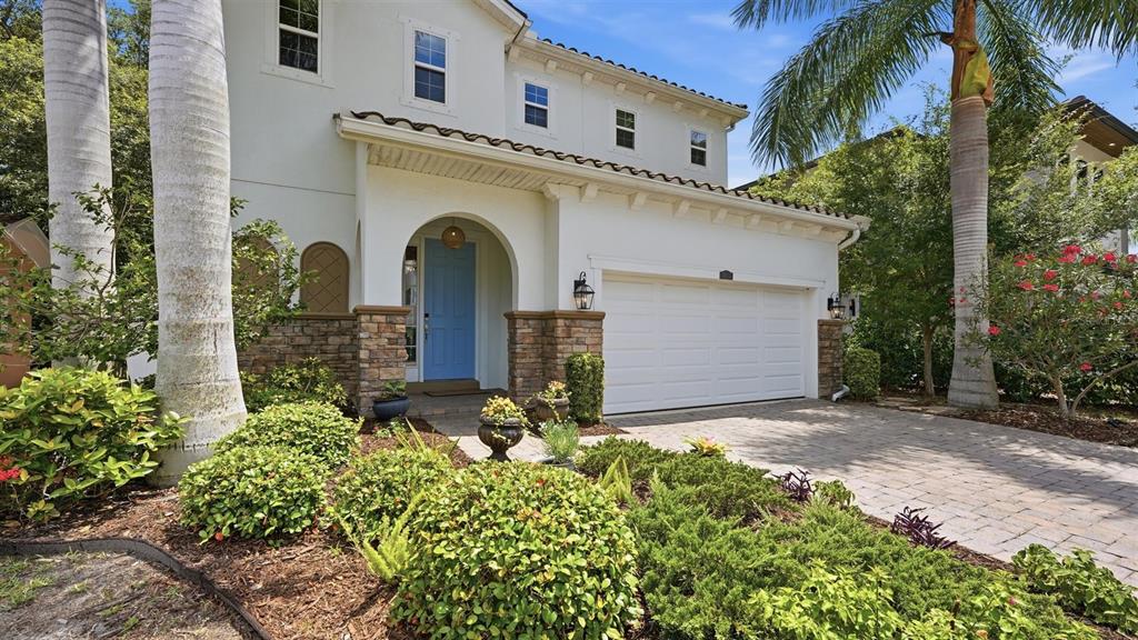 A two-story house with a white stucco exterior, stone accents, and a blue front door — 1850 MAGNOLIA STREET, SARASOTA, FL