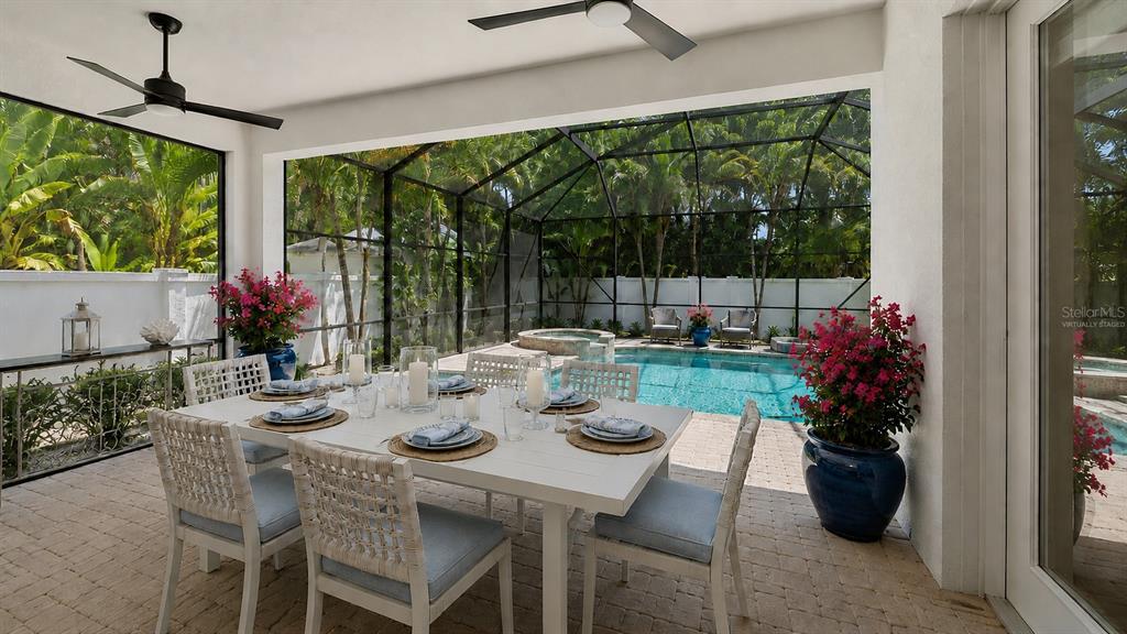 A covered patio features a dining set, a pool, and a spa inside a screened enclosure — 1850 MAGNOLIA STREET, SARASOTA, FL