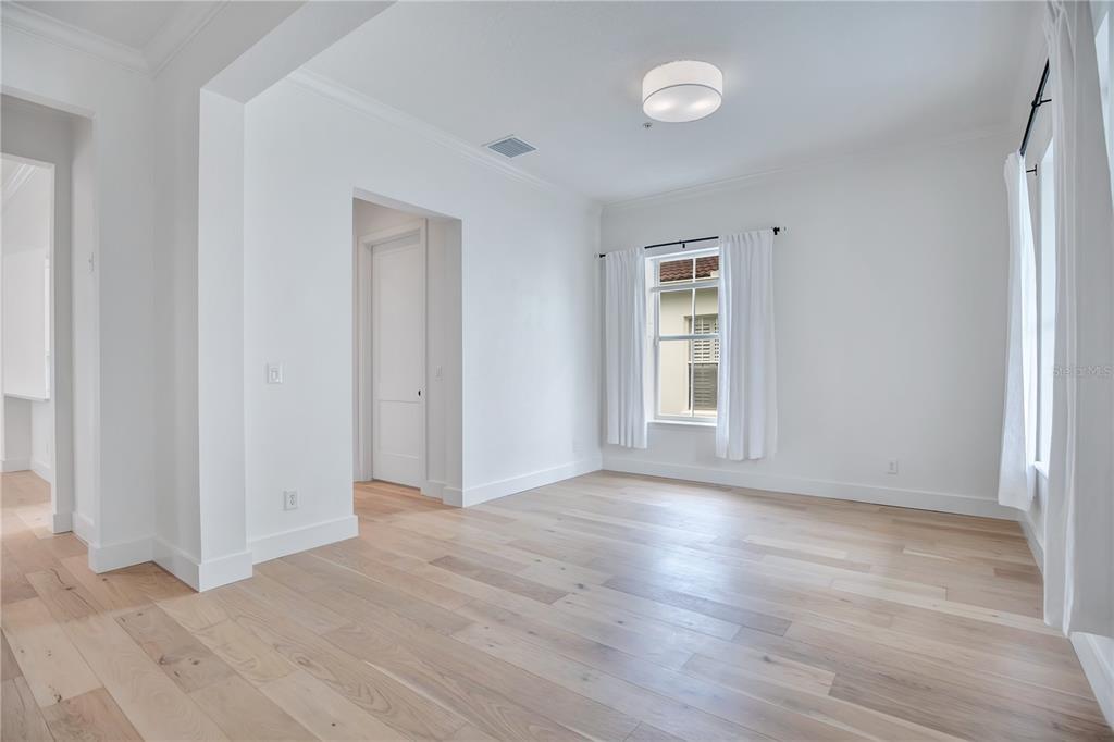 An empty room with white walls, light wood flooring, and a window with white curtains — 4041 HAWS LANE, ORLANDO, FL