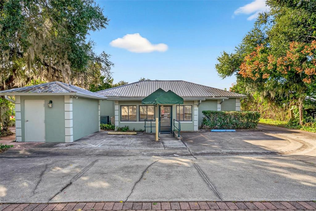A single-story commercial building with a metal roof, green exterior, and a small attached shed — 1318 S EUSTIS STREET, EUSTIS, FL