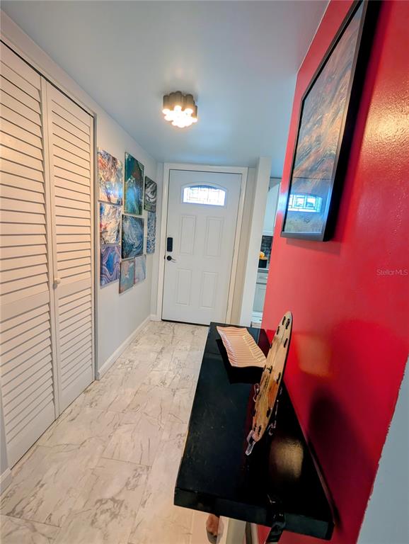 A dining room features a glass-topped table, six chairs, modern pendant lights, and wall art — 1243 S MARTIN LUTHER KING JR AVENUE UNIT B205, CLEARWATER, FL