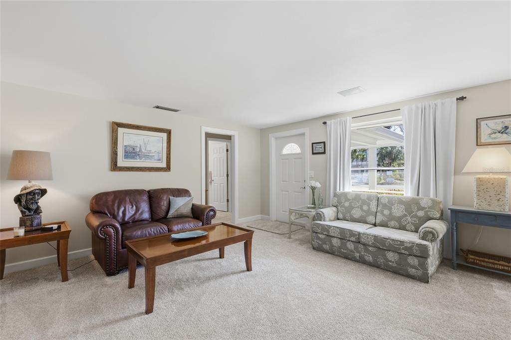 A living room features a leather sofa, a floral sofa, and a wooden coffee table — 109 TERN DRIVE, ANNA MARIA, FL