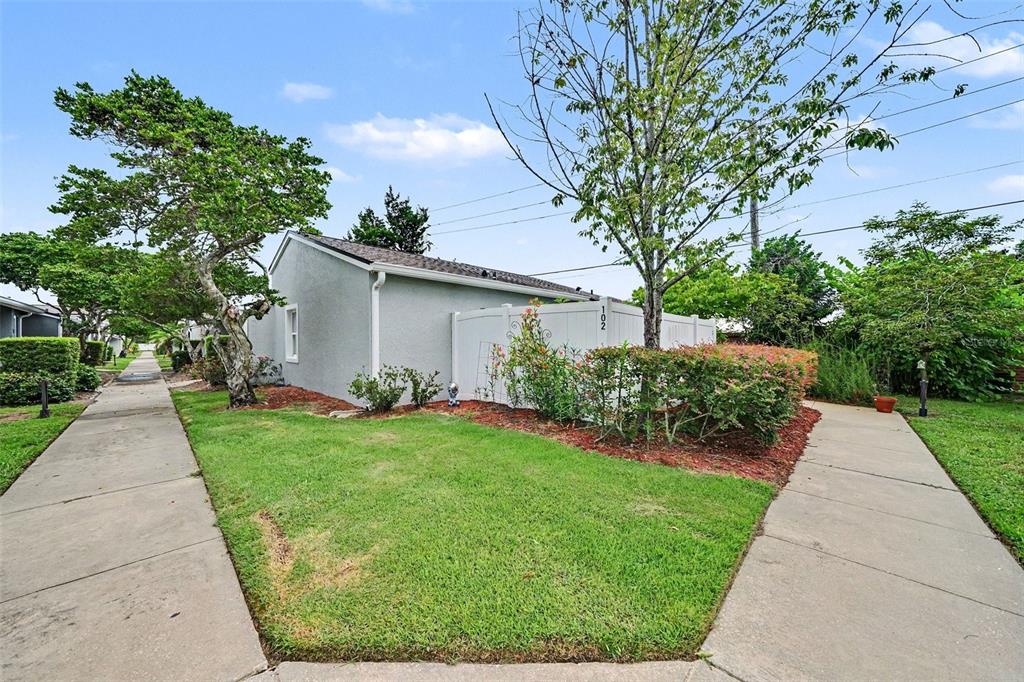 A gray house with a white fence and a sidewalk leading to the entrance — 102 DORCHESTER SQUARE, LAKE MARY, FL