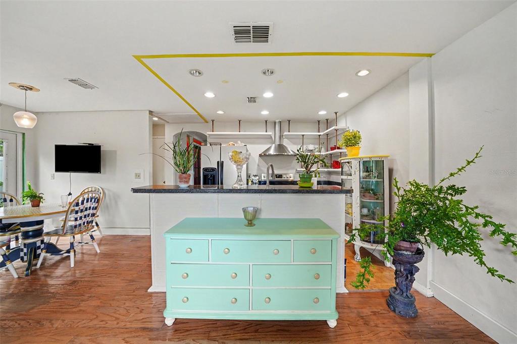 A kitchen features a mint green dresser, a breakfast bar, and a dining area nearby — 102 DORCHESTER SQUARE, LAKE MARY, FL
