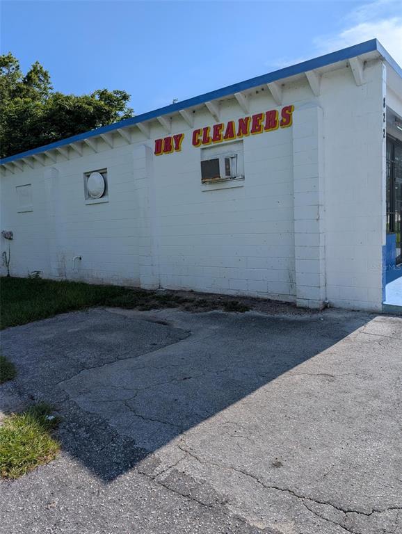 The exterior of a white concrete block building with a dry cleaners sign — 822 SW BROADWAY ST, OCALA, FL