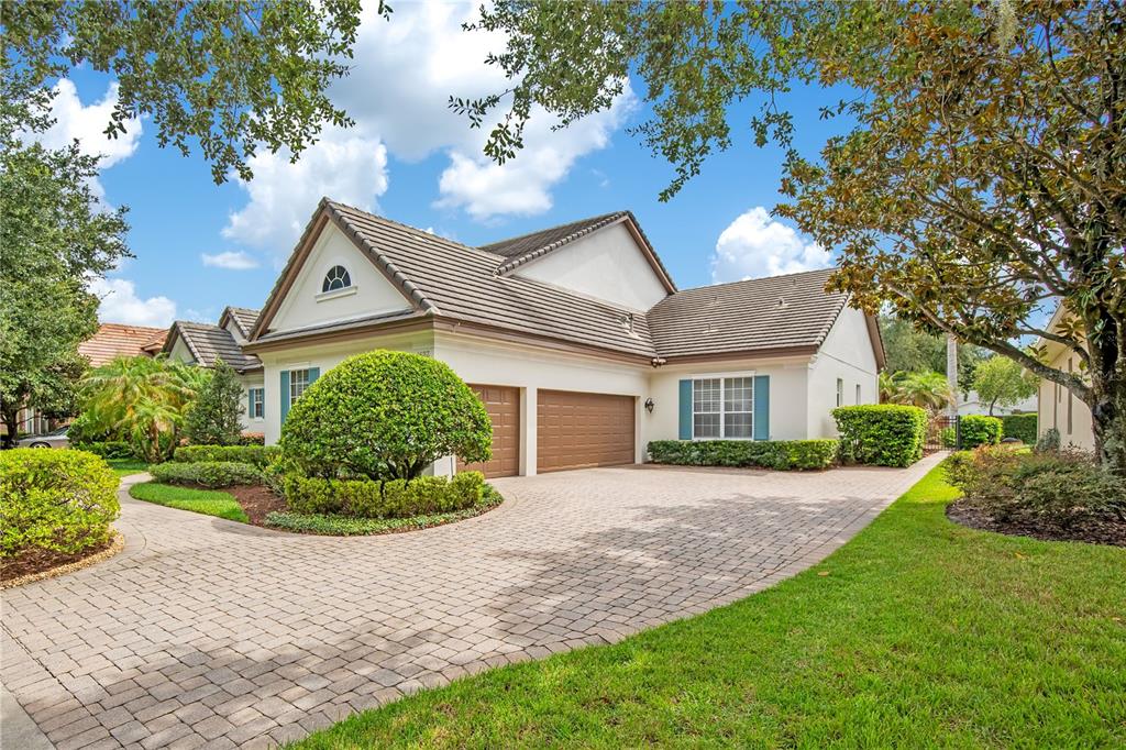 A single-story house with a white facade, blue shutters, and a paved walkway — 1623 CONWAY ISLE CIRCLE, BELLE ISLE, FL