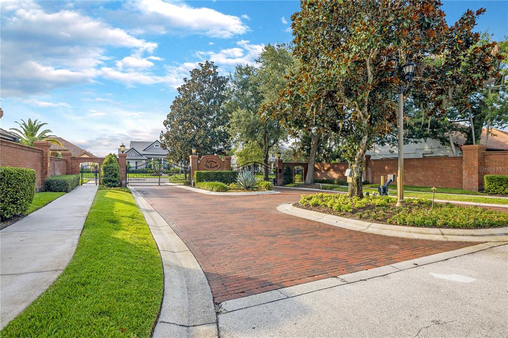 A front entrance with a brown door, arched transom window, and blue shutters on white walls — 1623 CONWAY ISLE CIRCLE, BELLE ISLE, FL